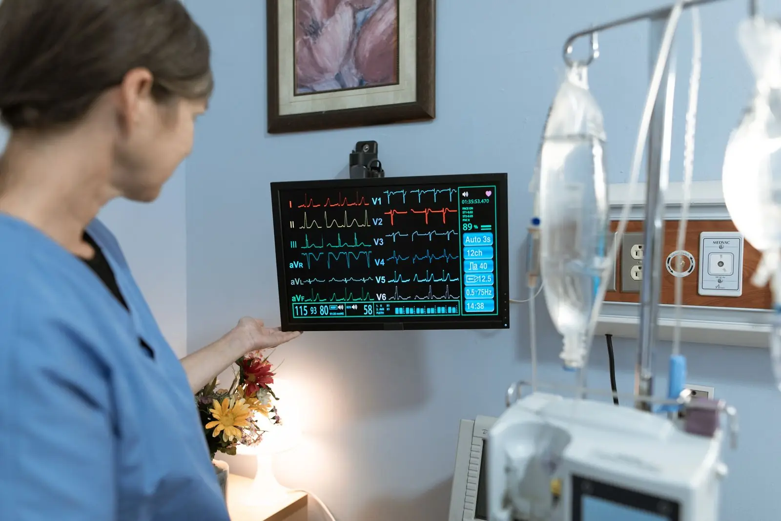 Clinician checking a patient monitor in intensive care
